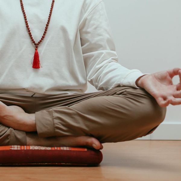 Close-up of a person's hands in a mudra gesture during meditation.